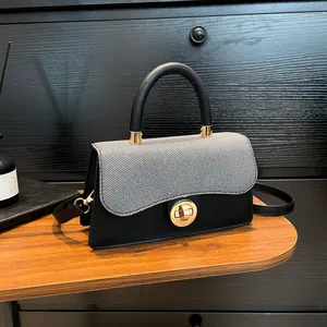 Chic black leather and grey fabric handbag with golden metal twist lock and top handle