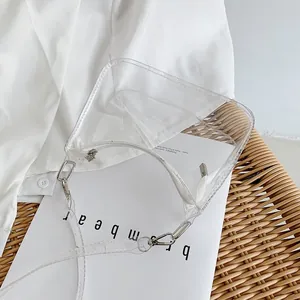 Macro shot of a transparent PVC shoulder bag featuring white zipper and silver hardware details