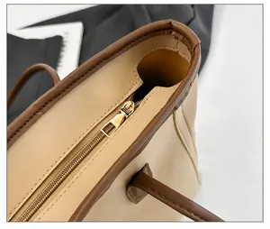 Makroaufnahme des glatten goldenen Reißverschlusses und der Nähte einer zweifarbigen Tasche