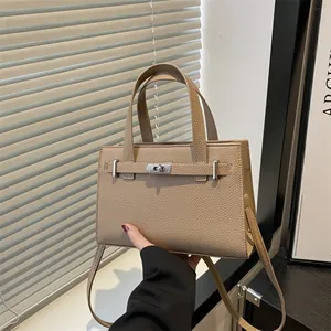 Elegant beige lychee grain leather handbag with silver turn-lock and shoulder strap