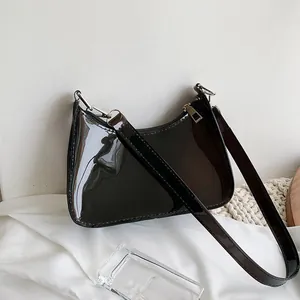 Close-up of black patent leather baguette bag with silver hardware and high-gloss finish