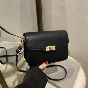 Vintage black crossbody bag with gold metal twist lock and matte leather finish