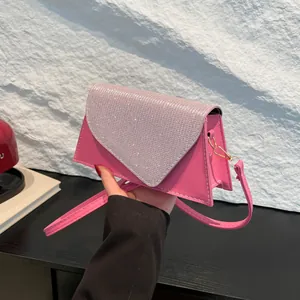 Sac bandoulière rose avec strass, coutures blanches et bandoulière amovible vue à la main