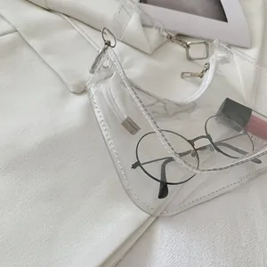 Detail view of transparent PVC half-moon bag with white stitching and silver zipper