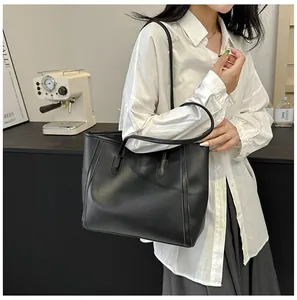 Klassische matte schwarze Shopper-Tasche mit schmalen Riemen in stilvollem Ambiente