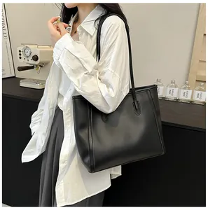 Minimalistische mattschwarze Einkaufstasche an der Schulter für den Büro-Look