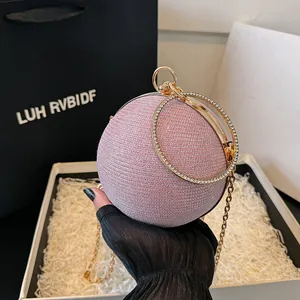 Sac de soirée sphérique rose avec finition pailletée et poignée anneau strassée