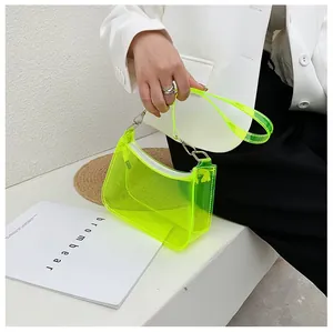 Close-up of a neon green transparent PVC underarm bag with a zipper and silver metal buckles