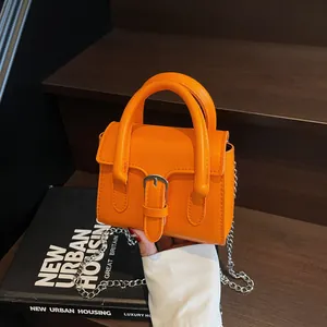 Modische leuchtend orangefarbene Mini-Handtasche mit silberner Schnalle und Kettenriemen