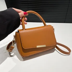 Sac à main classique marron caramel avec fermoir doré présenté dans un studio moderne