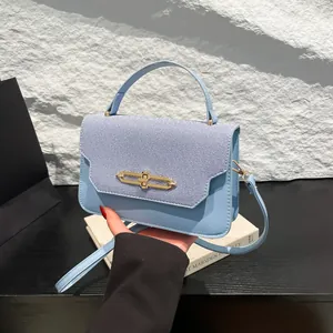 Elegante borsa a mano celeste con chiusura dorata e design patchwork in pelle e tessuto
