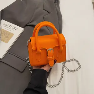 Piccola borsa quadrata arancione vivace con catena d'argento e chiusura a patta