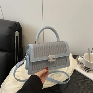 Elegante lichtblauwe crossbodytas met geweven flap en zilveren metalen gesp als detail