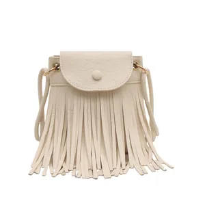 Minimalist cream bohemian fringe crossbody bag with gold metal rings and tassel detail