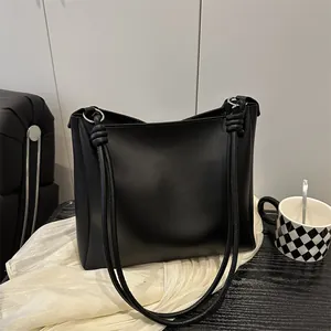Classic black matte leather tote bag with elegant silver rings and knot details
