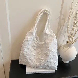Minimalistische witte draagtas met bloemenkanttextuur en een stijlvol schouderontwerp