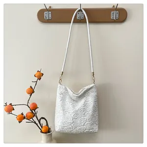 Close-up of intricate white floral crochet lace texture and slender leather shoulder strap
