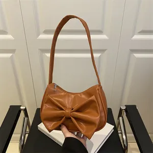 Sac hobo élégant en cuir marron caramel avec grand nœud et design minimaliste chic