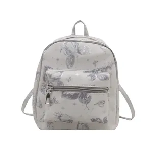 Mini backpack with butterfly and star prints featuring front pocket and top handle