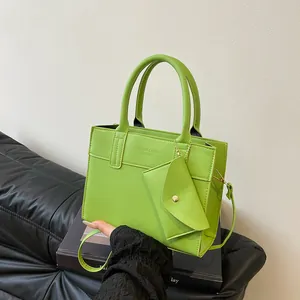 Light green leather handbag with small envelope coin purse on black display box