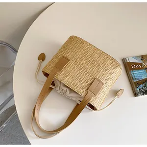 Close-up of woven straw handbag featuring leather handles and drawstring inner lining pouch