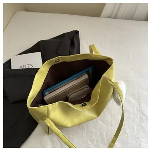 Draufsicht auf geräumige gelbe Totebag mit Plüsch-Anhänger und großem Innenraumvolumen