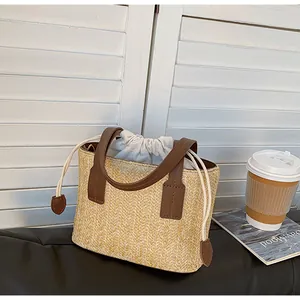 Close-up of straw woven tote with leather handles and drawstring lining detail