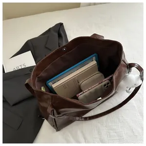 Innenansicht der dunkelbraunen Tragetasche mit Platz für Tablet, Handy und Bücher