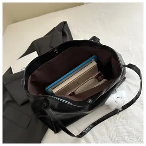Draufsicht auf das Innenleben der schwarzen PU-Leder-Einkaufstasche mit Tablet und Büchern