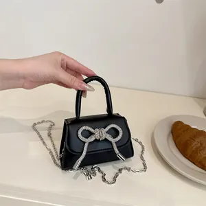 Mini zwarte satijnen handtas met strass-strik en zilveren kettingriem voor dames