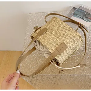 Detail of square woven straw bag with leather strap and cotton drawstring lining