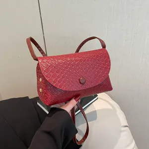 Μινιμαλιστική κόκκινη τσάντα με πλεκτή υφή και χρυσό πριτσίνι που κρατιέται στο χέρι