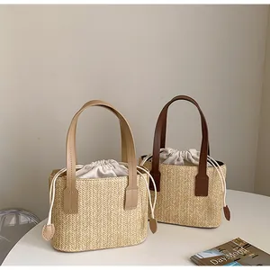 Close-up of straw woven tote bags with drawstring liners and leather handles