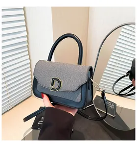 Detail of color-block mini handbag with golden D buckle and textured grey fabric
