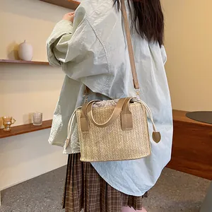 Summer woven straw bucket bag with drawstring closure and crossbody strap for beach vacation