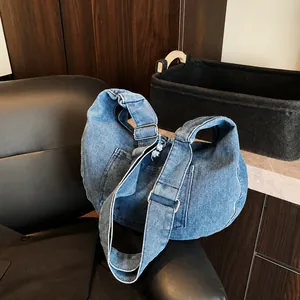 Deep blue denim hobo bag on a black leather chair in a cozy indoor setting