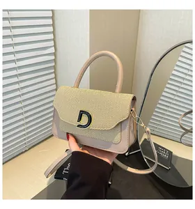 Detailed close-up of beige woven texture flap and metallic D-buckle on handbag