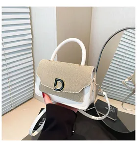 Detail of contrast stitch straw and white leather handbag with metal D buckle