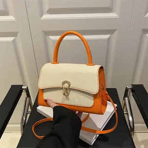 Elegante oranje en beige geweven crossbodytas met gouden hoefijzer gespsluiting