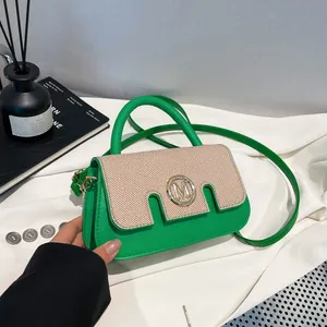 Chic green and beige paneled mini crossbody handbag with a stylish metal logo detail