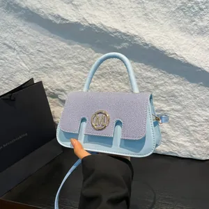 Light blue contrast crossbody bag with denim texture flap and golden M logo detail