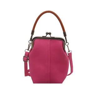 Hot pink canvas crossbody bag with vintage metal frame closure and brown top handle