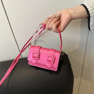 Trendy hot pink mini crossbody bag with carbon fiber texture and acrylic chain detail