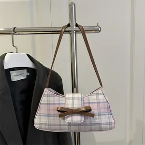 Pink and blue plaid underarm bag with a brown leather bow and stylish shoulder strap