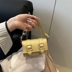 Mini gold woven crossbody bag with decorative buckles and acrylic chain handle