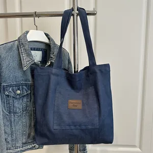 Sac fourre-tout en denim bleu foncé avec étiquette en cuir brun et grand espace intérieur