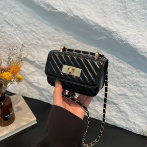 Quilted black mini crossbody bag with gold chain strap and turn-lock closure