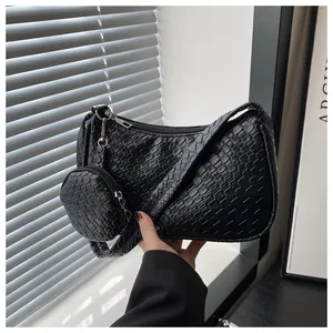 Detail der schwarzen gewebten Schultertasche mit passender runder Geldbörse und Reißverschluss