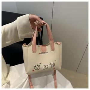Détail du sac cabas en cuir PU crème avec poignées roses et imprimé animalier