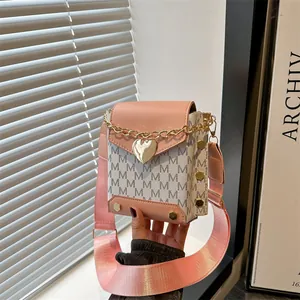 Bolso bandolera rosa y blanco con monograma, colgante de corazón y correa ancha
